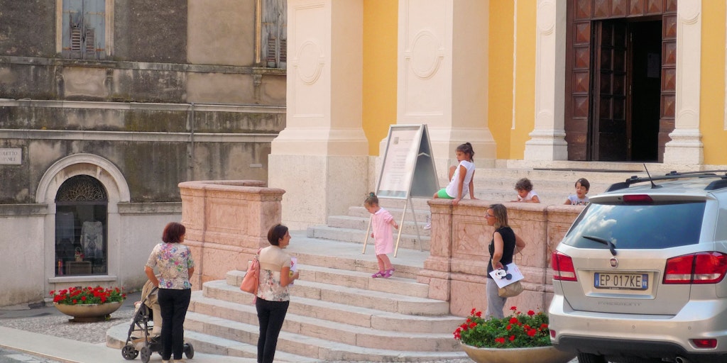 Children and their mothers stop for a chat and a little play on the town's church stairs on the way home from school and kindergarten